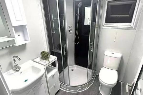 Salle de bain compacte avec douche, lavabo et WC dans une maison modulaire