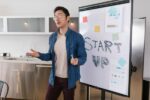 Entrepreneur présentant une start-up avec un tableau blanc marqué "START UP"