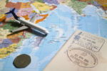 Carte du monde avec avion miniature, passeport et pièce de monnaie
