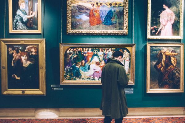 Visiteur de galerie d'art admirant des peintures encadrées