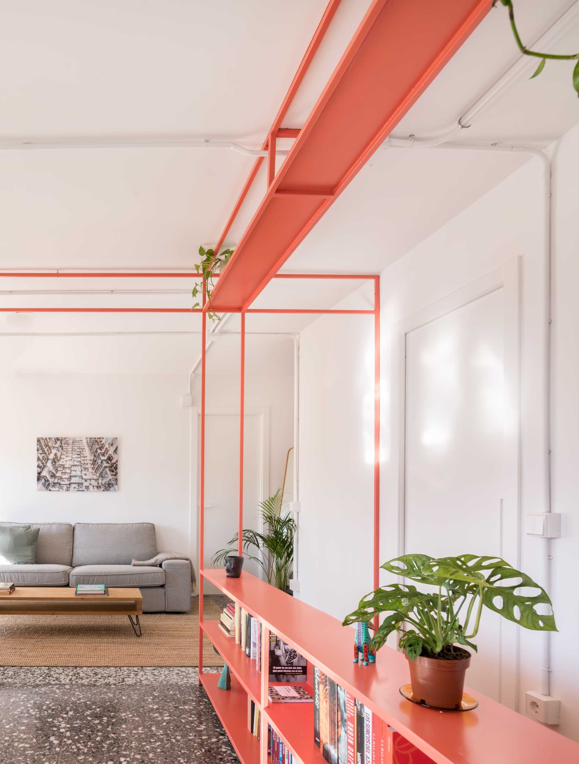 Bibliothèque moderne ouverte dans un appartement lumineux, délimitant les espaces de vie.