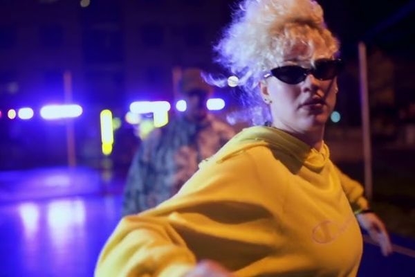 Danseuse et danseur de breakdance en tenue décontractée et lunettes noires dans le clip "Nouvelle Ballade", éclairée par des lumières néon, symbolisant l'esprit libre et décalé de Razobik Tome 2.