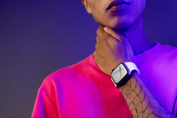 Personne portant une montre connectée au poignet, vêtue d’un t-shirt coloré, symbolisant la fusion de la mode et de la technologie.