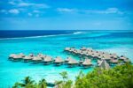 Vue aérienne de bungalows sur pilotis dans les eaux turquoise de Bora Bora.