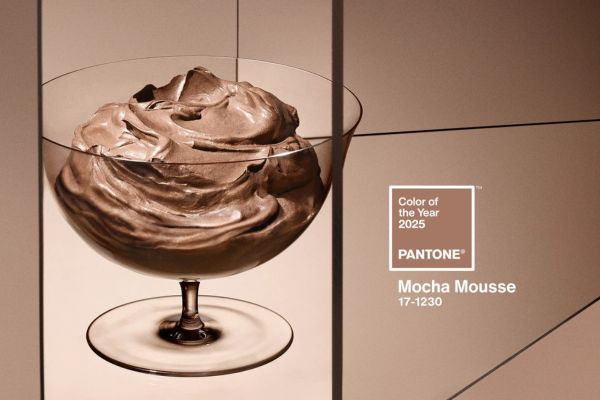 Une coupe élégante remplie de mousse chocolatée, mettant en avant la couleur Pantone 2025, Mocha Mousse (PANTONE 17-1230), avec le logo officiel Pantone. Crédit photo : Pantone.