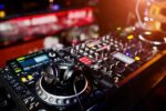 Vue rapprochée de l'équipement DJ professionnel, incluant des platines, un contrôleur et des casques, utilisés pour mixer de la musique dans une ambiance live.