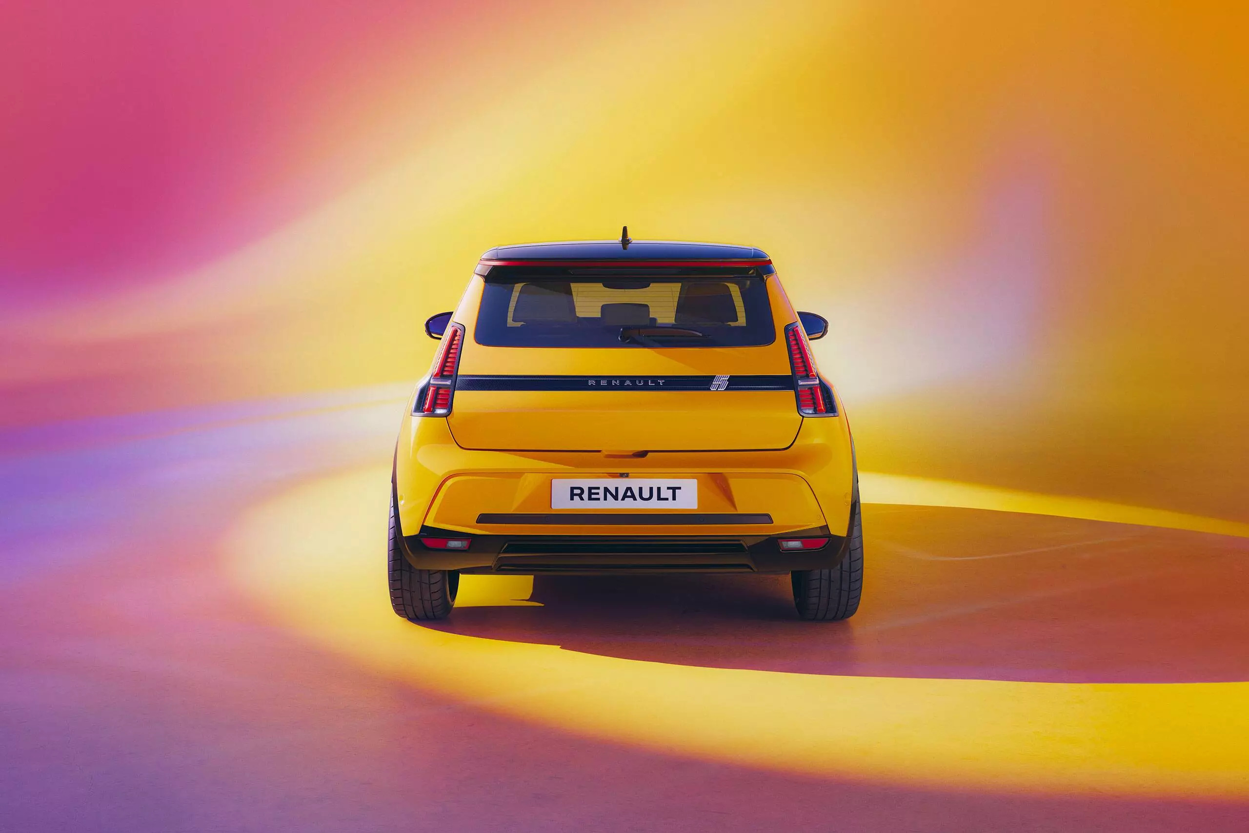 Vue arrière de la Renault 5 électrique avec un design jaune et des feux LED modernes.